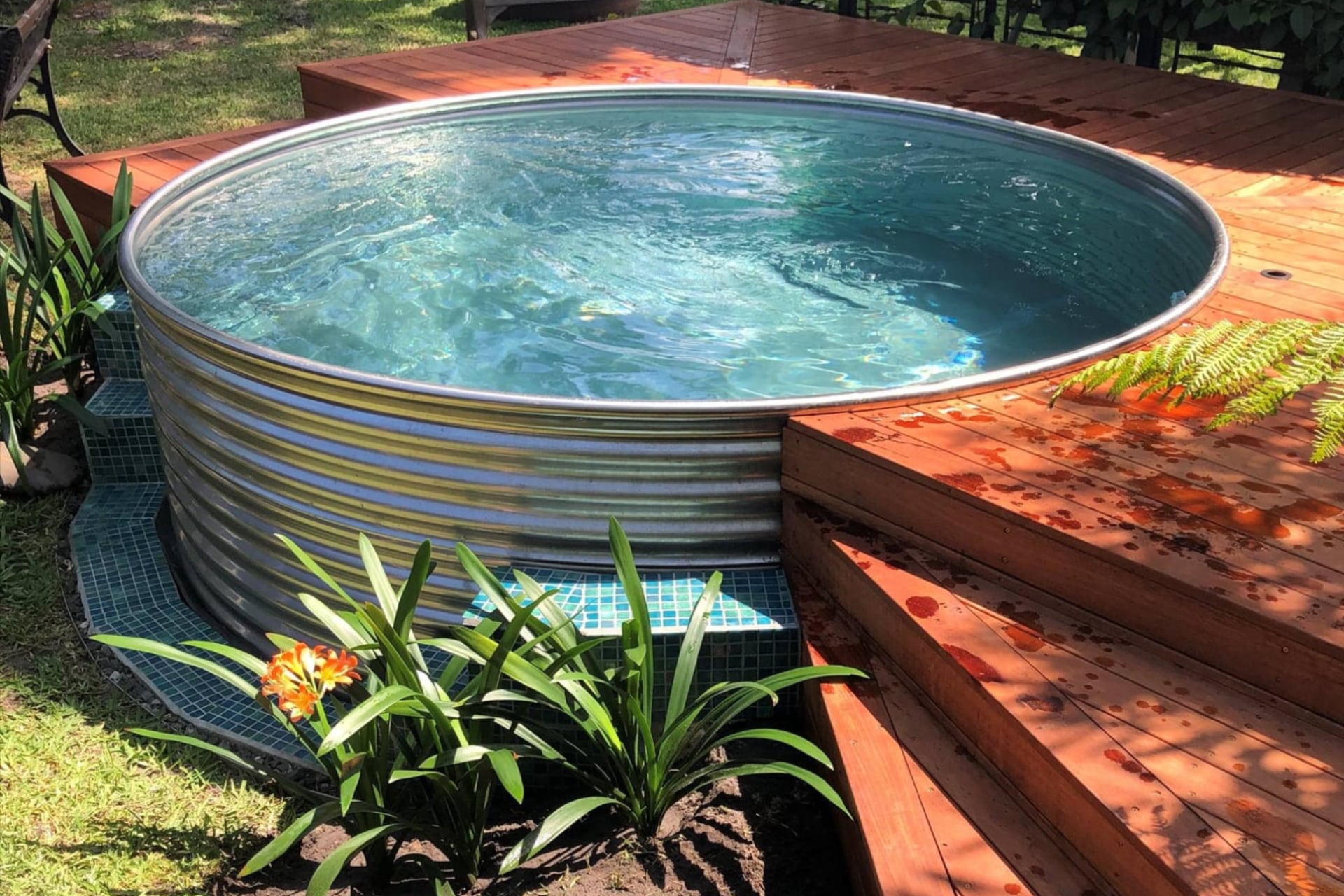 Round Outback plunge pool surrounded by timber decking and garden plants